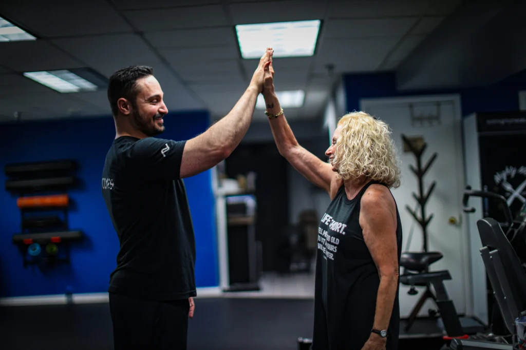 A Foundation Fitness Annapolis coach celebrating a training win with a member